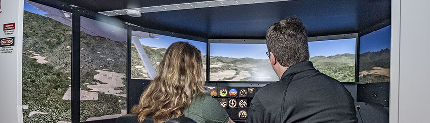 photo of a student and instructor in a flight simulator