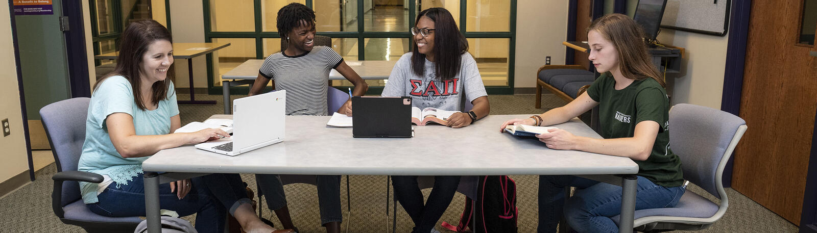 photo of a students sitting a table working on a project