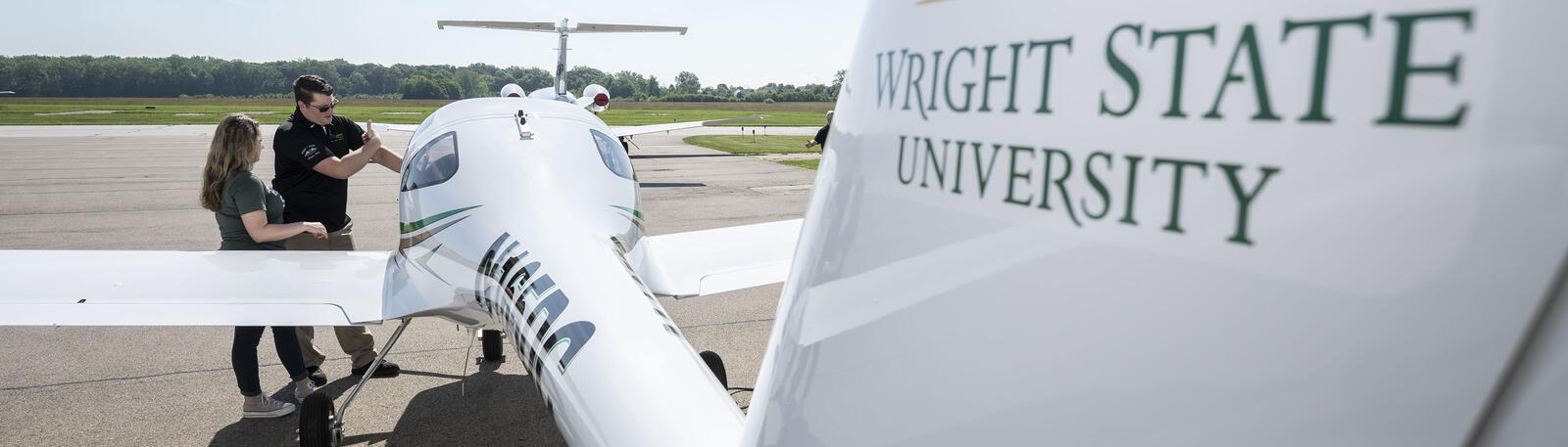 photo of a student and an instructor next to a plane
