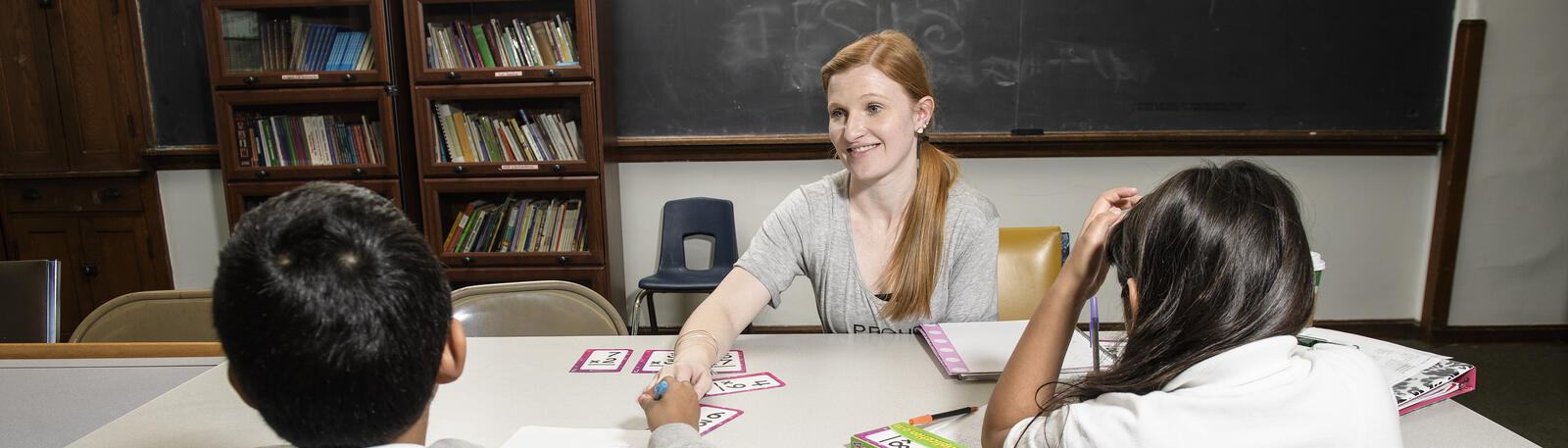photo of a student teacher with young students in a classroom