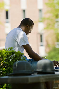 photo of a student sitting outside on campus