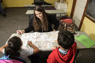 photo of a student teacher with young students in a classroom