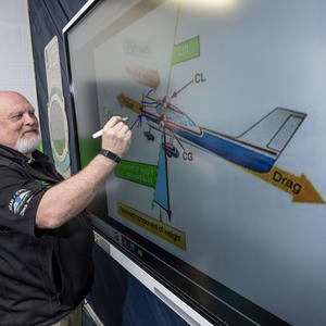 photo of an instructor writing on a whiteboard